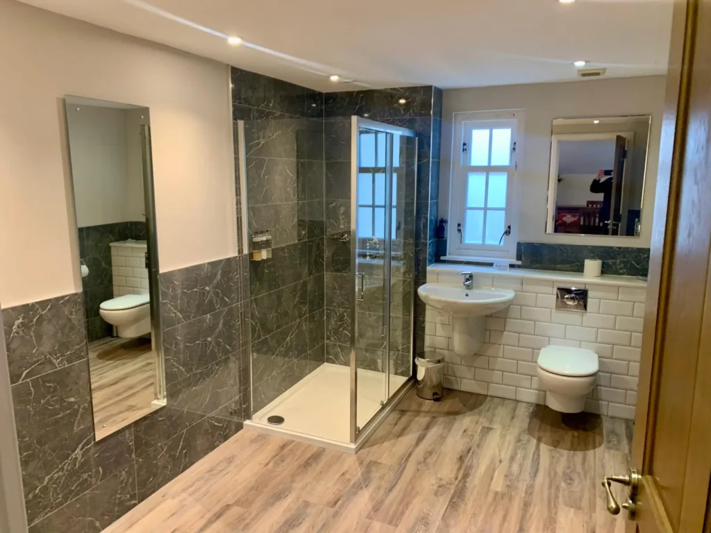 Luxury fitted bathroom with freestanding bath and tiled feature wall