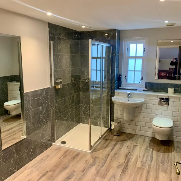 Luxury fitted bathroom with freestanding bath and tiled feature wall
